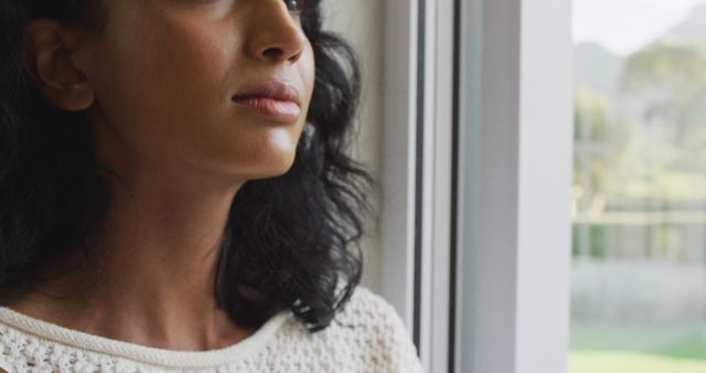 Happy biracial woman looking through the window and smiling - Download Free Stock Photos Pikwizard.com