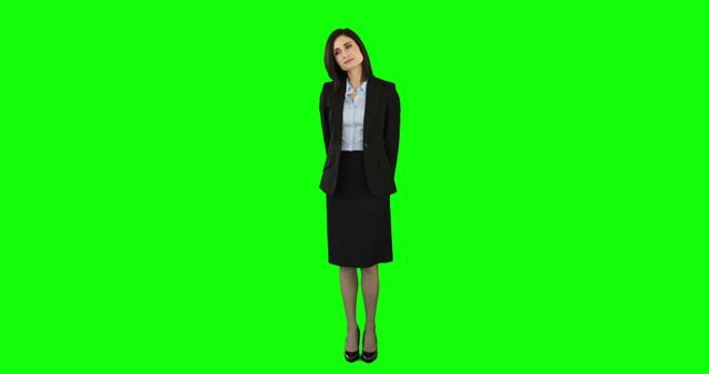 Photo of a businesswoman standing on a green screen background, wearing formal office attire. Ideal for presentations, corporate brochures, business websites, or any project requiring a professional look with easy background removal and replacement.