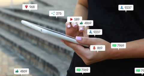 Holding tablet displaying social media notifications, likes, comments, followers, engagement