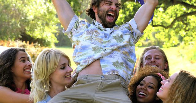 Friends Celebrating Lifts Happy Man in Park on Sunny Day - Download Free Stock Images Pikwizard.com