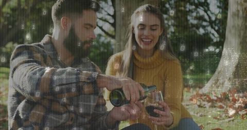 Couple Enjoying Wine Picnic with Technology Concept Overlay