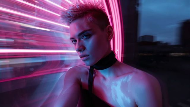 Neon-ring rooftop portrait featuring androgynous model with pixie cut and black choker