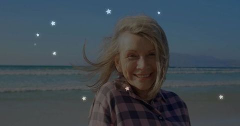 Smiling Senior Woman Enjoying Beach Day with Decorative Star Overlays