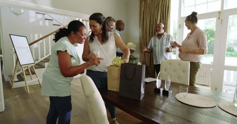 Diverse Senior Friends Celebrating with Gifts and Drinks