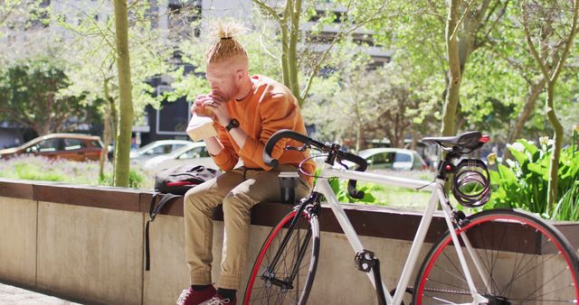 Young Man Enjoying Snack Outdoors Near Bicycle - Download Free Stock Images Pikwizard.com