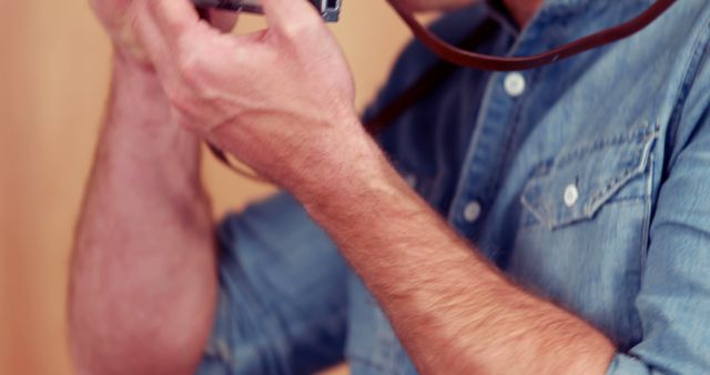 Man in denim shirt using vintage camera indoors - Download Free Stock Images Pikwizard.com