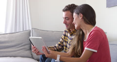 Couple Using Tablet and Smartphone at Home