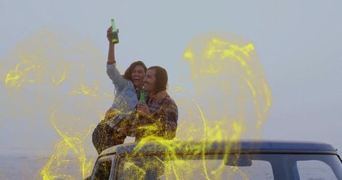 Joyful Couple Celebrating on SUV Rooftop by Ocean Provides Vibrant Happiness