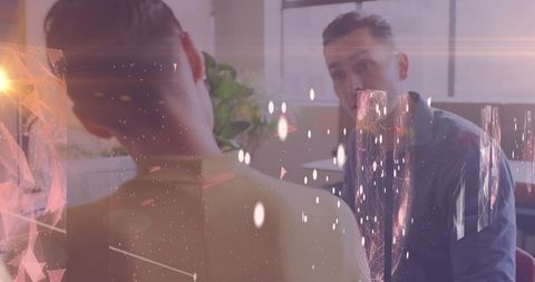 Office colleagues maintaining eye contact discussing project in modern workspace with light overlays