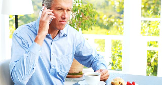 Businessman Having Breakfast and Talking on Mobile Phone - Download Free Stock Images Pikwizard.com