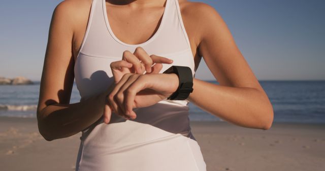 Woman Using Smartwatch on Beach During Workout - Download Free Stock Images Pikwizard.com