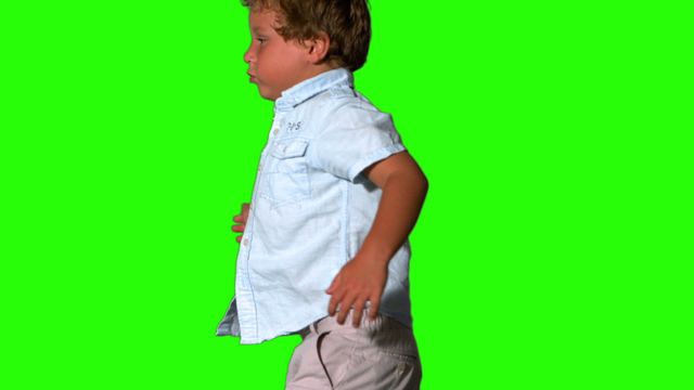 Boy jumping and turning on green screen can be used for visual effects, educational content, advertisement, or creative motion graphics projects.