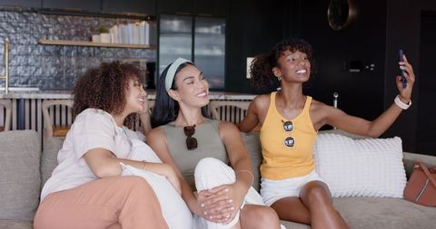 African american friends taking selfie in modern open-plan living room