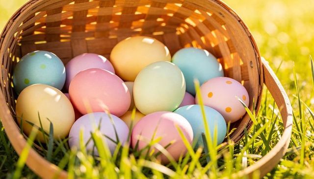 Pastel easter eggs resting in woven basket on sunlit grass, spring outdoor decor