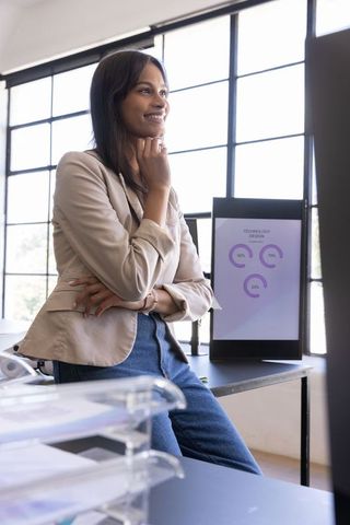 Asian professional analyzing data on desk in modern open-plan office