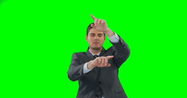 This image features a male businessman in a formal suit standing in front of a green screen background. He is actively posing and pointing with his hands, making various gestures, suggesting the potential for custom animations or graphics to be added. Perfect use for creative projects, corporate training materials, advertising, presentations, and media production needing customizable backgrounds and professional human subjects.