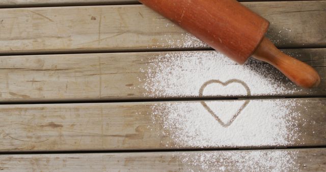Image of rolling pin and heart shape in flour on wooden surface. baking, food preparing, taste and flavour concept.