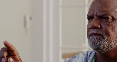 Senior Man Focusing Intently While Painting at Home