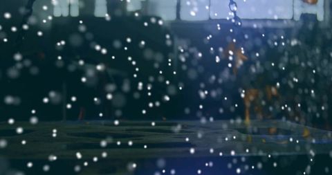 Glittering droplets casting bokeh across metal ledge, backlit window, moody blue light