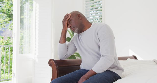 Stressed Elderly Man Sitting on Bed in Bright Room - Download Free Stock Images Pikwizard.com