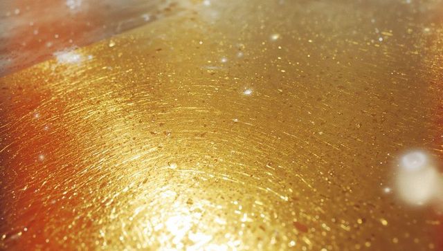 Glowing golden metallic surface with concentric polish patterns