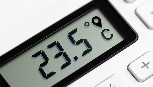 Closeup digital thermostat display showing 23.5°c on minimal white device for smart home