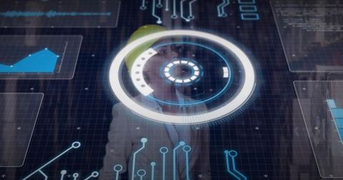 Engineer wearing hard hat interacting with futuristic HUD display and data dashboards