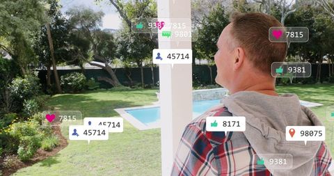 Caucasian Man Observing Social Media Icons in Lush Garden