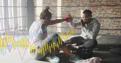 High-fiving boxing partners training together with stock chart overlay for fitness data