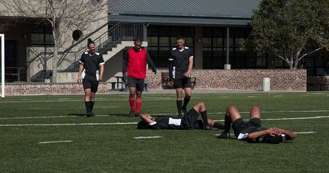 Soccer Players Resting and Discussing Strategy on Field