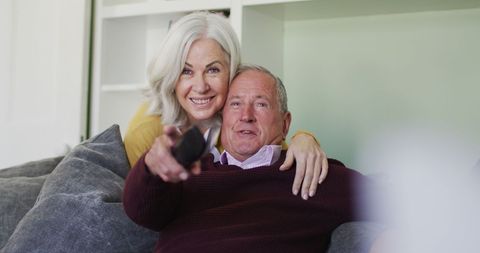 Happy Senior Couple Relaxing on Sofa Smiling Together