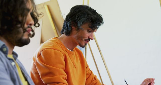 Focused Artist in Orange Sweater Creating Artwork - Download Free Stock Images Pikwizard.com