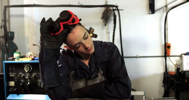 Tired Female Welder Taking a Break in Workshop - Download Free Stock Images Pikwizard.com