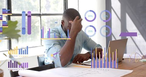 Focused Analyst Leaning Over Blueprints with Digital Analytics Interface