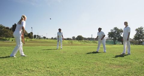 Female Cricket Team Training Outdoors with Bat and Ball