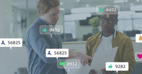 Pointing colleague reviewing printed charts with social metrics overlay in workspace
