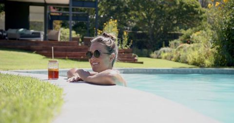 Woman Enjoying Refreshing Beverage While Relaxing in Pool on Sunny Day - Download Free Stock Images Pikwizard.com