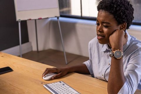 Professional woman using computer mouse in modern office