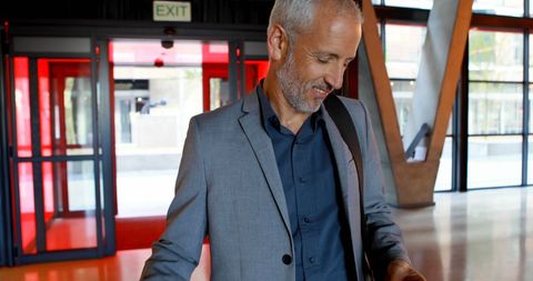 Mature businessman engaging with laptop in modern hotel lobby