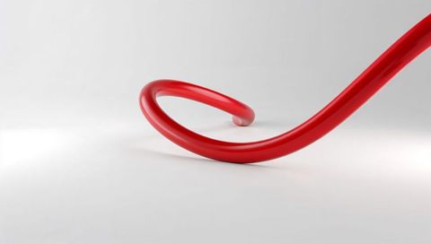 Glossy red tubular spiral curling across white minimalist studio forming negative space