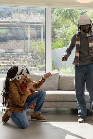 African american friends experiencing virtual reality at home with vr headsets