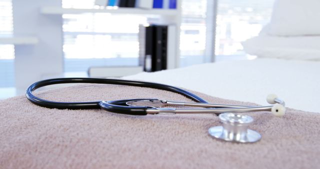 A stethoscope rests on a towel in a medical setting, with copy space. It symbolizes healthcare services and the readiness of medical professionals to provide care.
