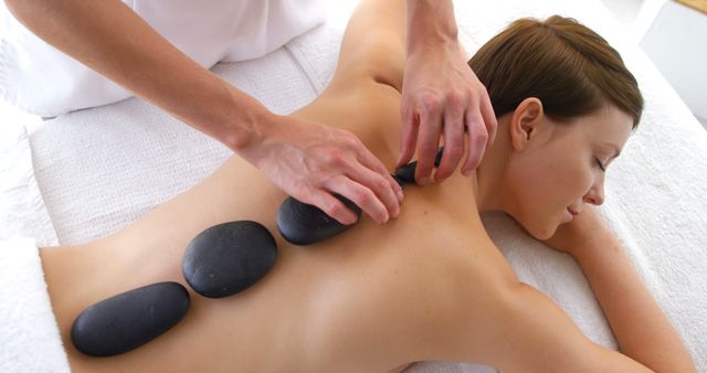Woman Receiving Hot Stone Massage Therapy in Spa - Download Free Stock Images Pikwizard.com