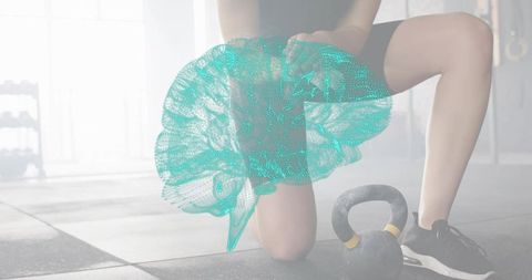Kneeling athlete presenting holographic brain overlay in gym for fitness mental training