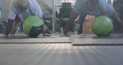African men performing medicine ball plank partner workout for core strength and endurance