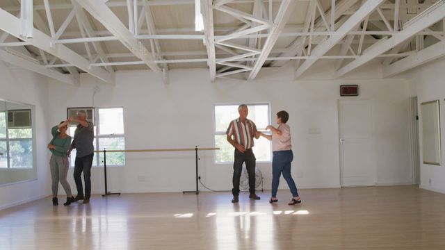 Couples are having an enjoyable time participating in a ballroom dancing class. This scene shows the fun and active lifestyle elderly people can have by engaging in social and physical activities. Ideal for promoting senior wellness programs, recreational activities, or community events.