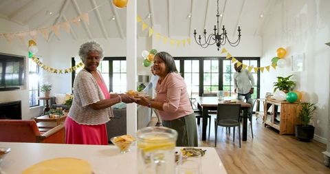 Senior friends decorating for joyful birthday celebration