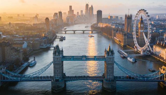 Golden hour aerial of tower bridge and london eye over river thames london skyline