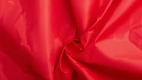 Swirling Red Satin Fabric Close-Up Glinting Folds Flowing Texture and Shimmering Sheen