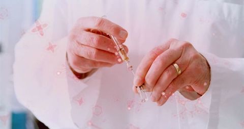 Hands preparing syringe with medical liquid in laboratory setting